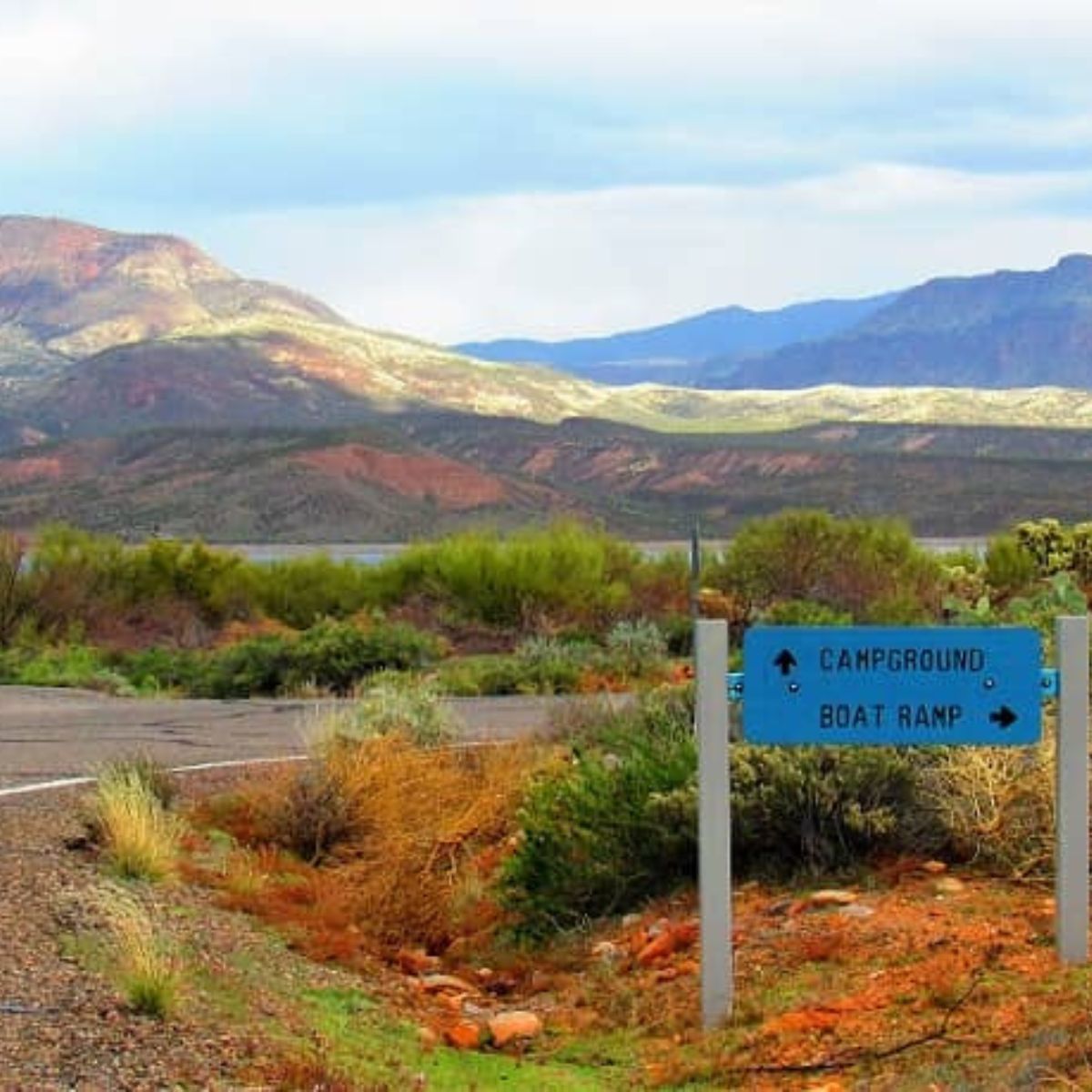 Entry road to Cholla campground and boat launch by a mountainside lake in AZ.